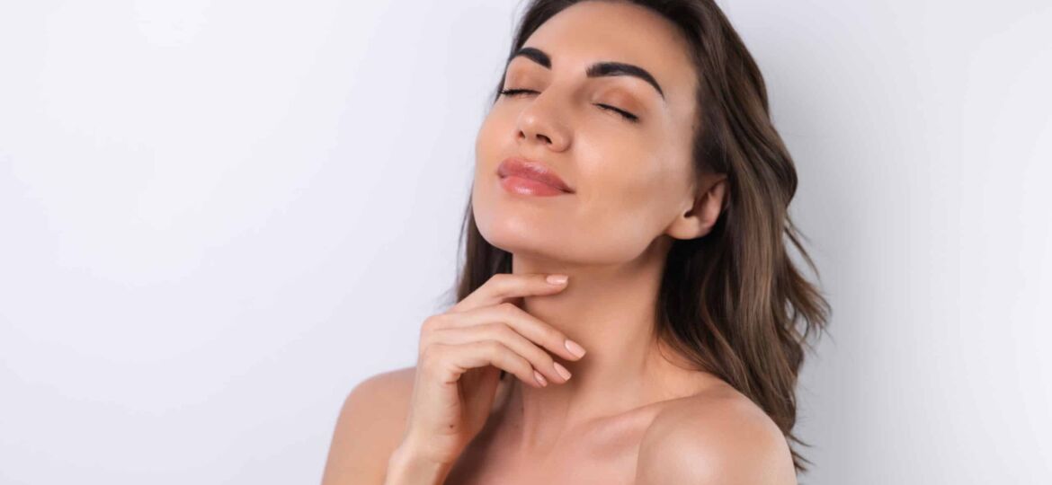 Woman touching her face after a facial lipo