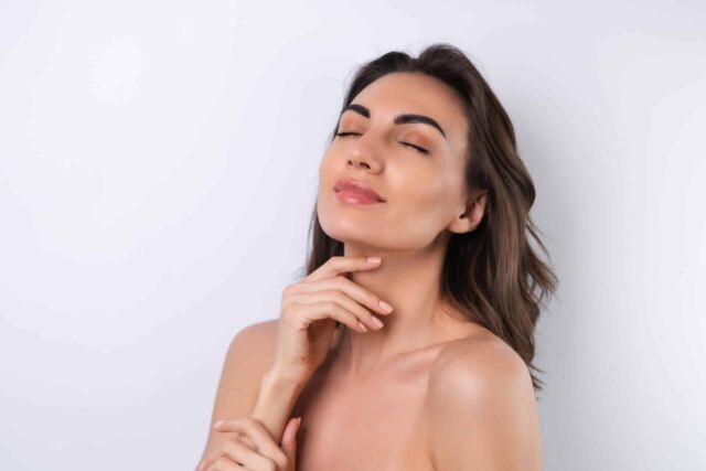 Woman touching her face after a facial lipo