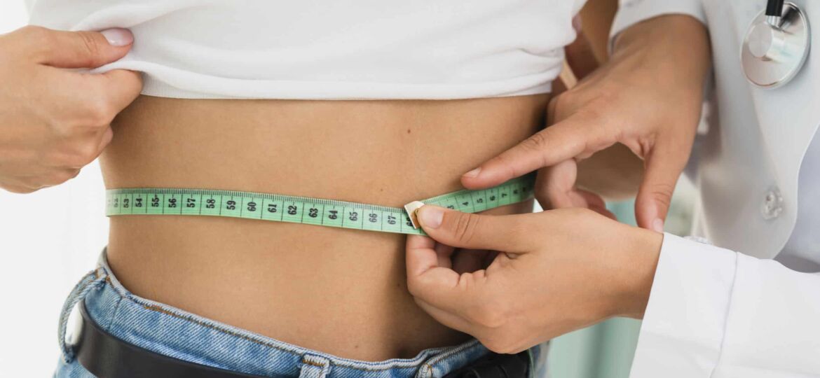 close up doctor measuring womans abdomen