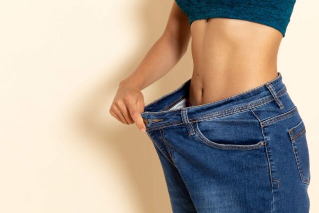 front view young female with fit body shirt jeans white wall