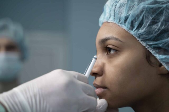 side view doctor checking nose job patient
