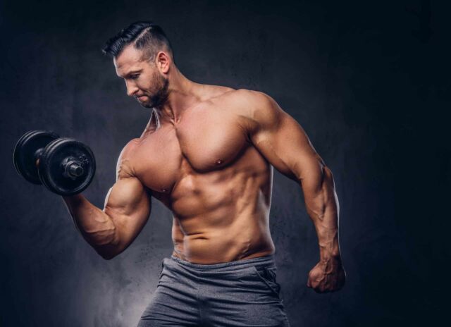 Portrait of a shirtless tall huge male with a muscular body in a underwear, posing in a studio.