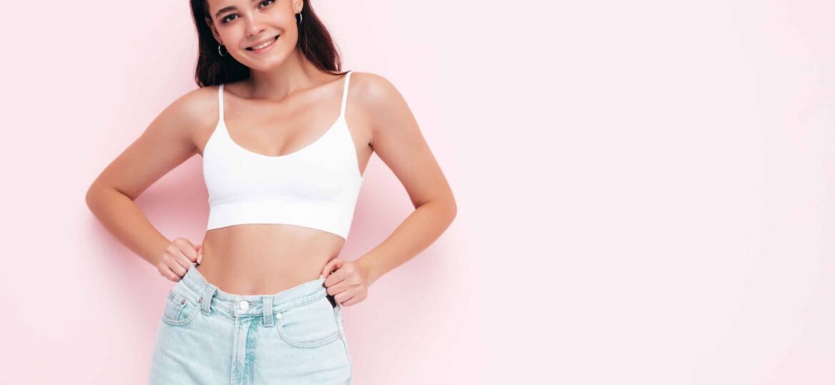 Young beautiful smiling female in trendy summer clothes. Sexy carefree woman posing near pink wall in studio. Positive brunette model having fun and going crazy. Cheerful and happy