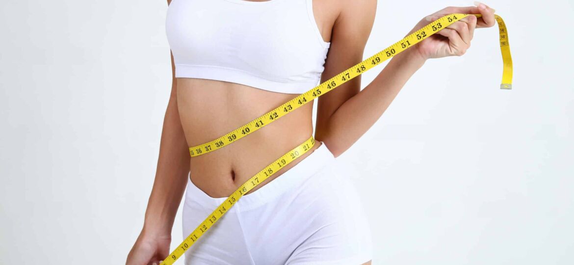 Young woman with beautiful body and measure tape
