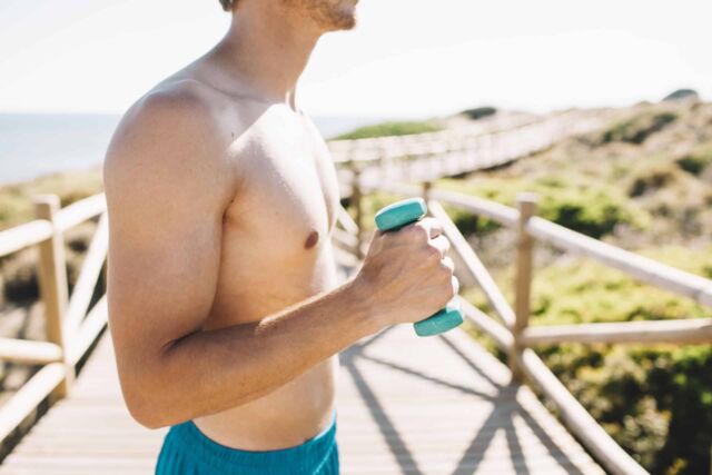 hombre-con-pesa-en-la-playa