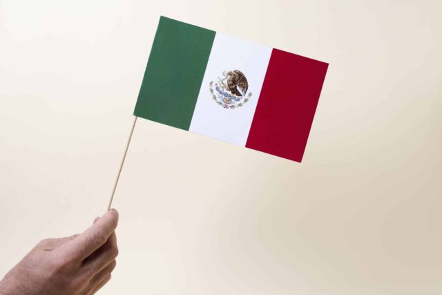 mano-que-sostiene-la-pequena-bandera-mexicana