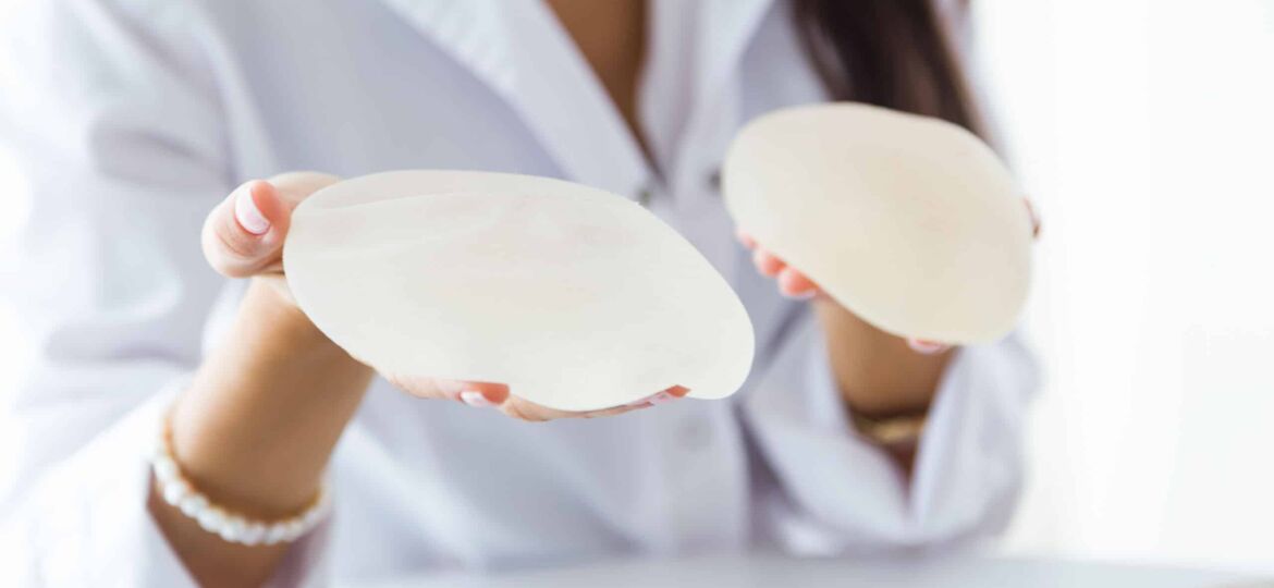 Female doctor choosing mammary prosthesis in the office.